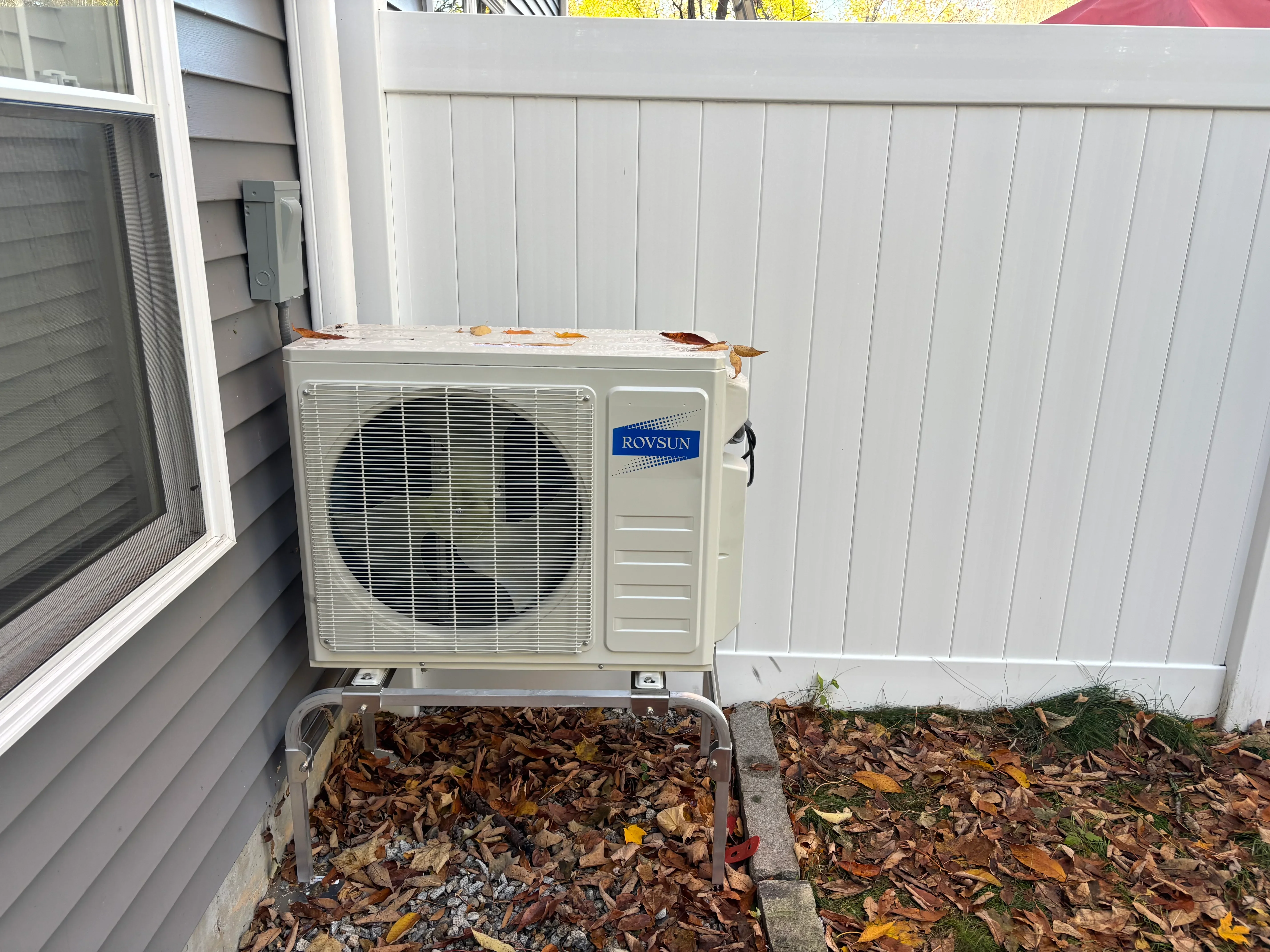 Rovsun mini-split heat pump outdoor unit mounted on white vinyl siding