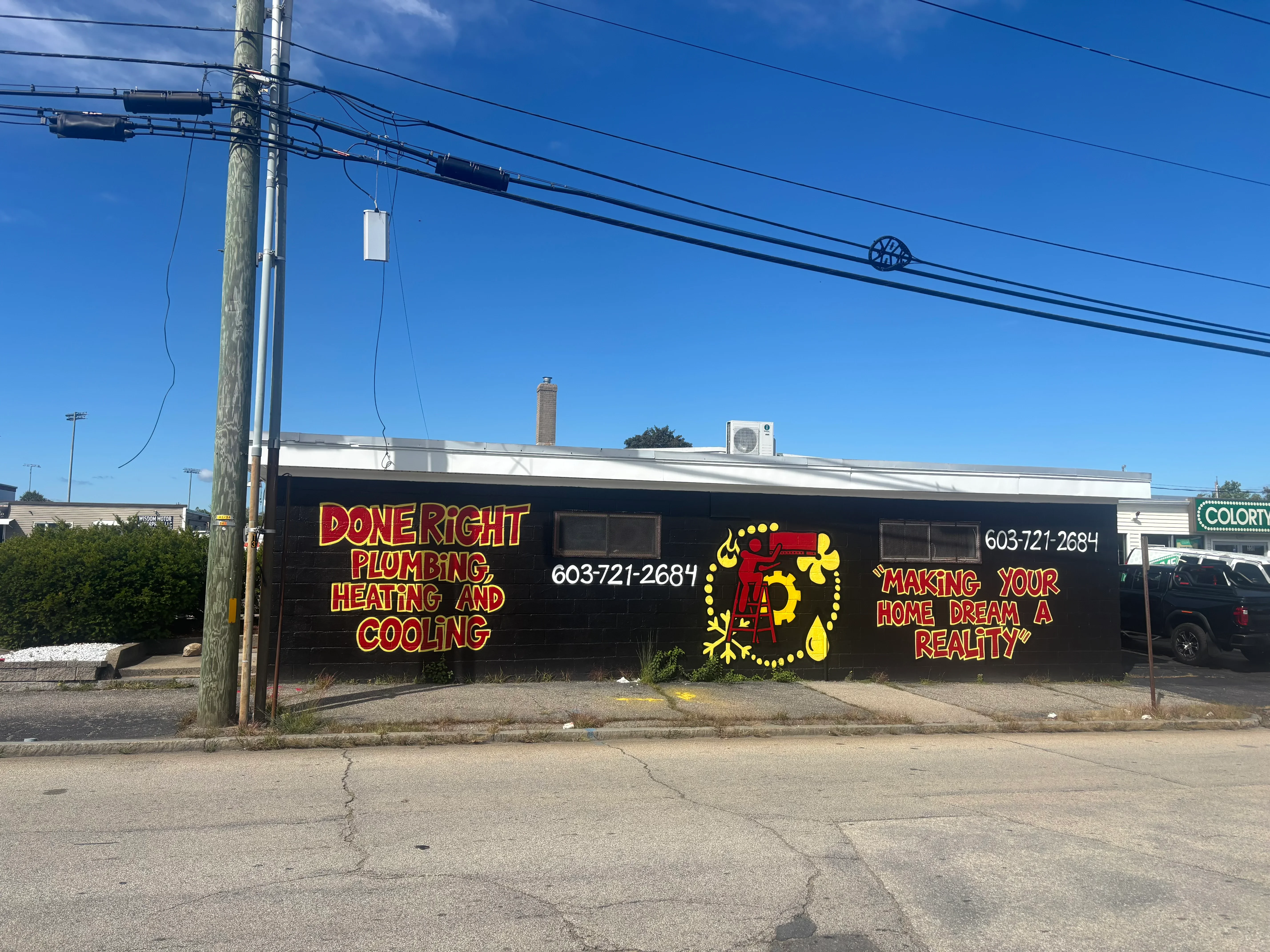 Commercial storefront with red and yellow DoneRight Plumbing signage on dark building exterior