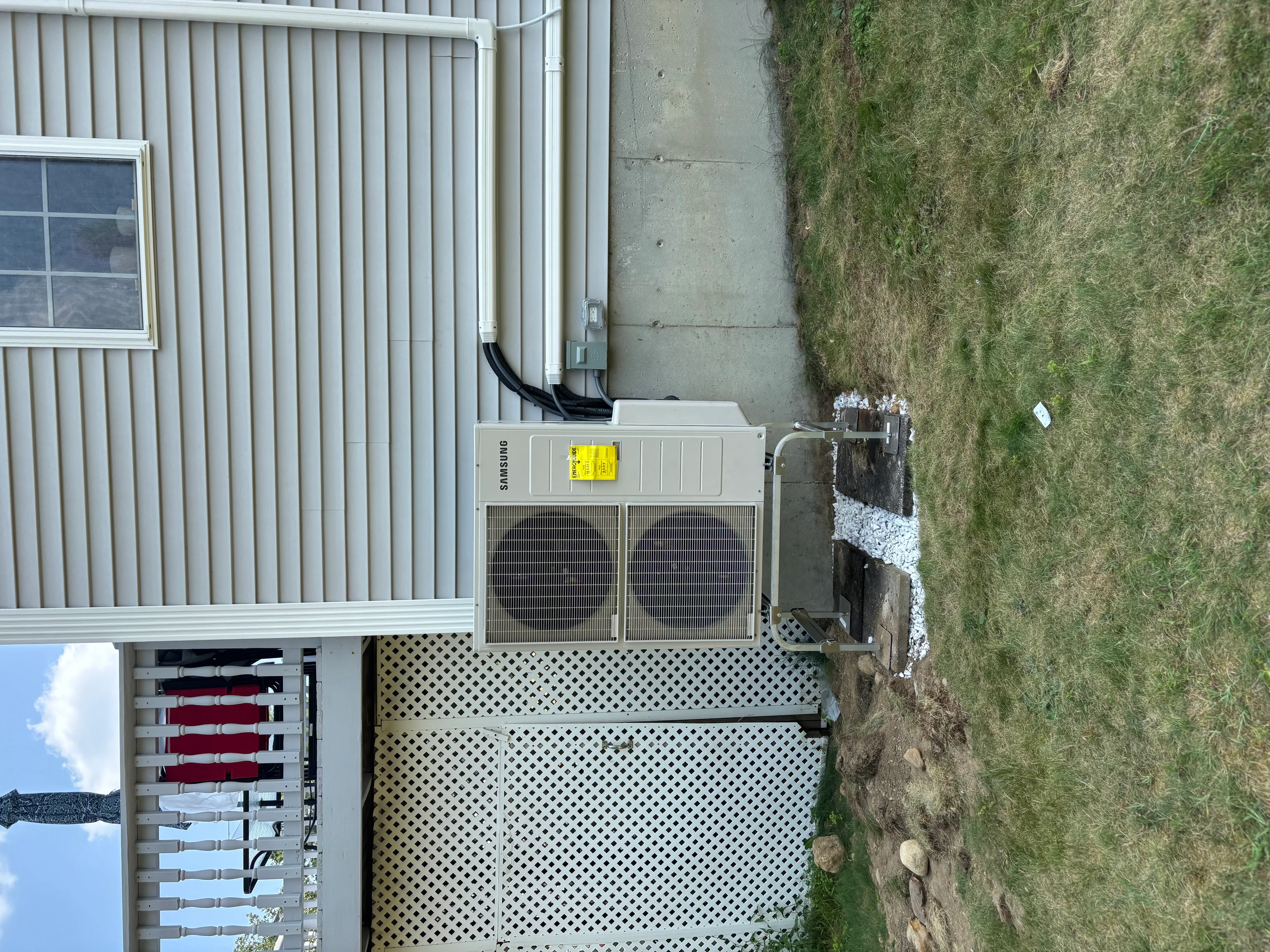 Installed Samsung HVAC condenser unit with dual fans and metal protective screening